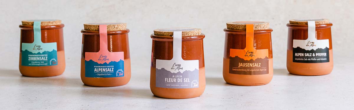 Fünf Salzspezialitäten von Essenz der Alpen in Tontöpfchen: Zirbensalz, Alpensalz, Alpen Fleur de Sel, Jausensalz sowie Alpen Salz & Pfeffer.